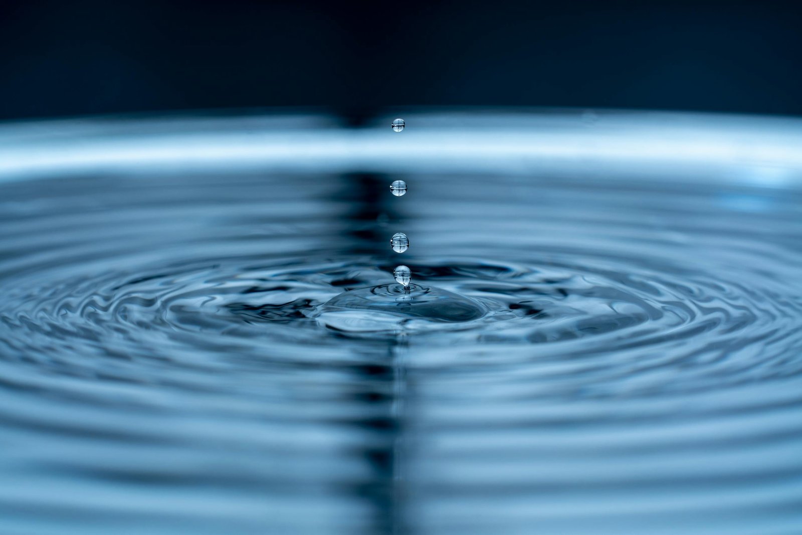 Mesmerizing capture of water droplets forming ripples on a smooth surface.